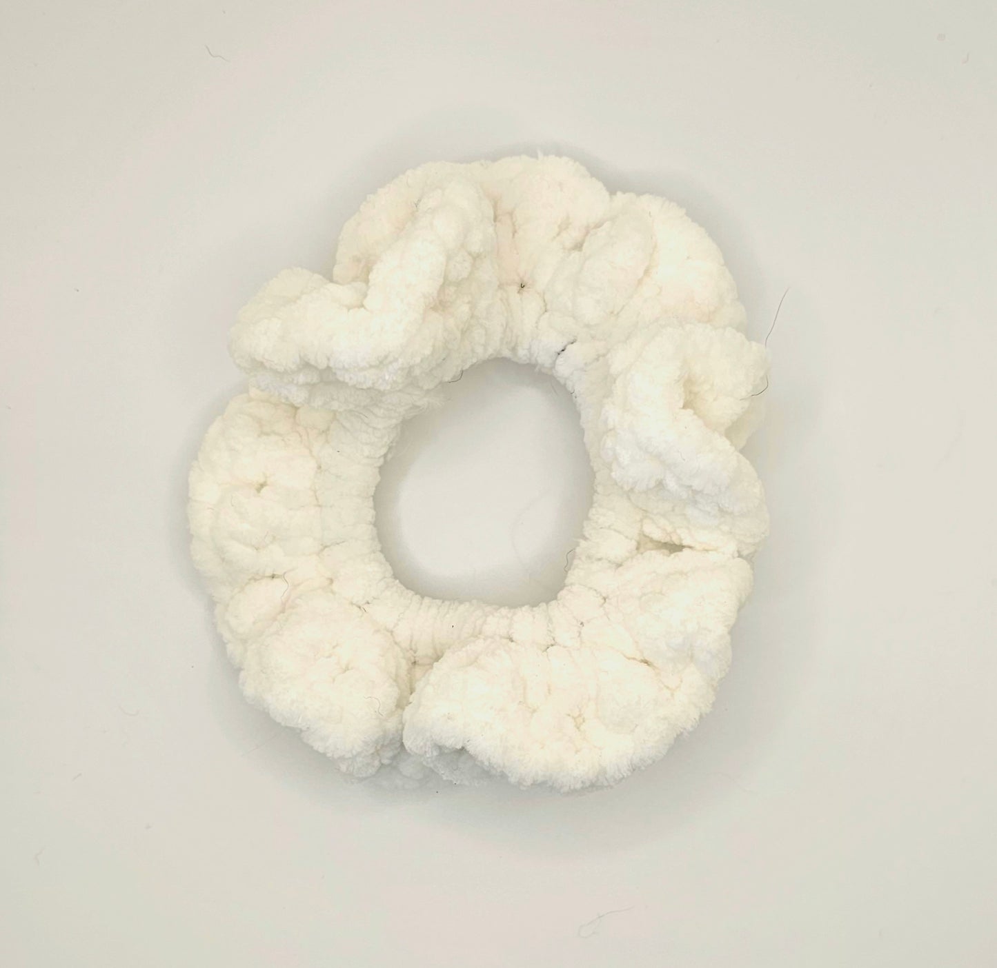 Velvet white yarn crochet around a hair elastic to create a ruffly scrunchie.