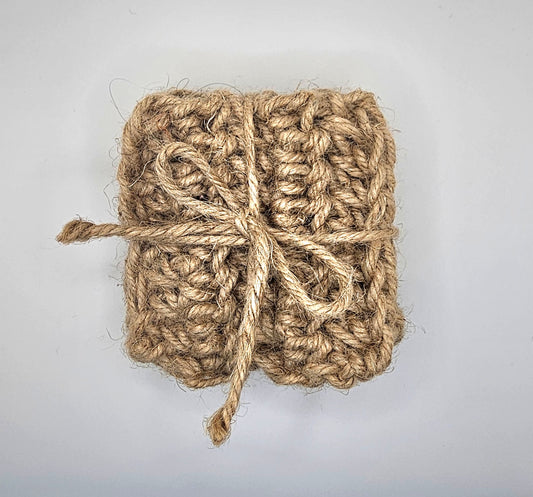 Set of coasters made from jute rope. The coasters are in a square shape and are tied together with the same material in a gift wrapping fashion.