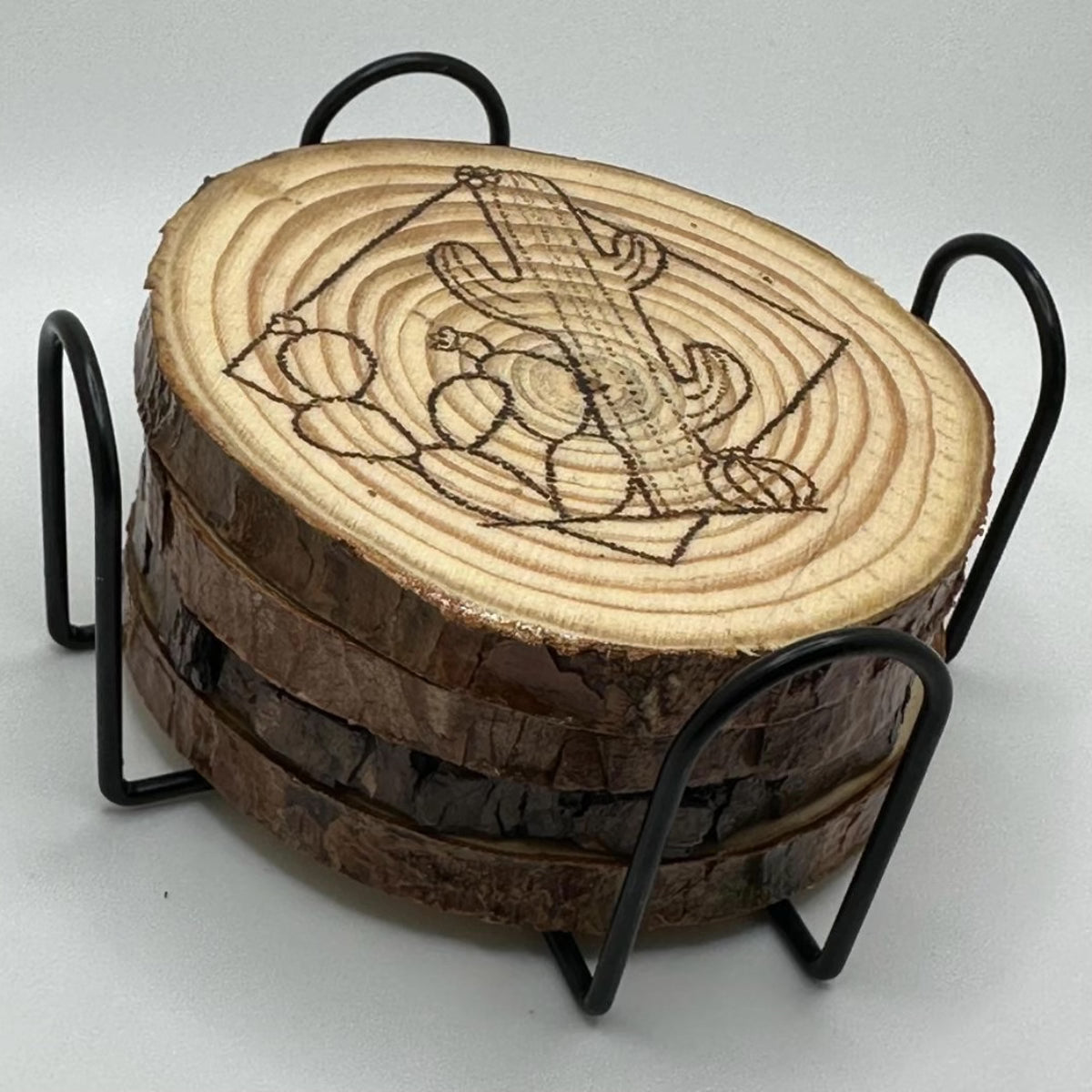 4 wooden disks stacked on top of each other. these disks sit inside a metal stand that encases them. The disk on top has a design of cacti inside a square burned onto it.
